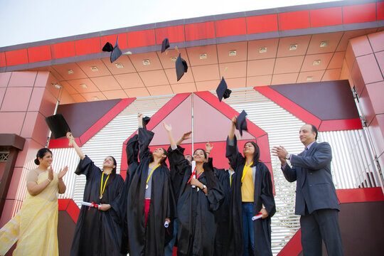 Graduate students throwing their hats in the air