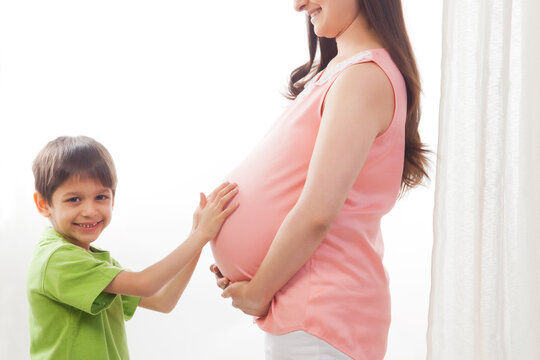 Portrait of boy touching mother pregnant belly