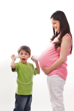 Boy reacting to sound from baby in pregnant mothers belly