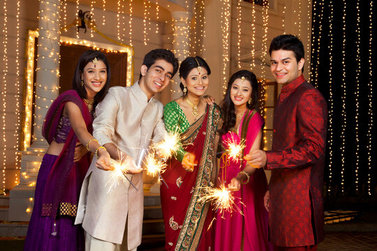 Portrait of friends holding sparklers