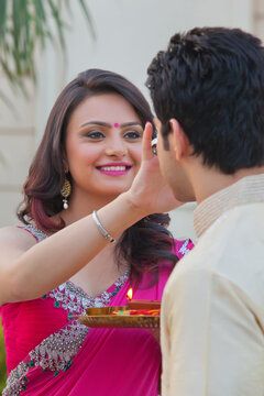 Woman putting tika on mans forehead