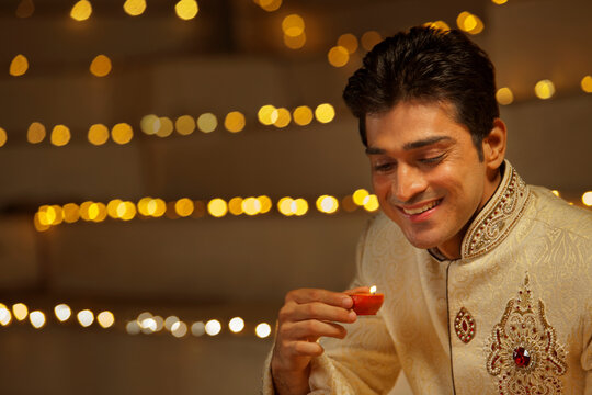 Man holding a diya