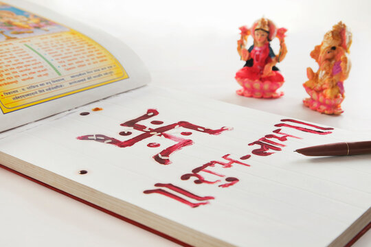 Ledger book and a pen with lakshmi and ganesha idol isolated on white background