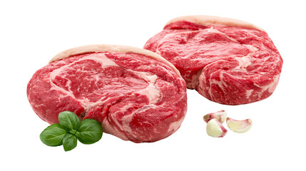 Obraz premium Two raw ribeye steaks with basil and garlic cloves