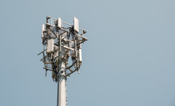 Close-up of a telecommunications cell tower with antennas against a clear sky