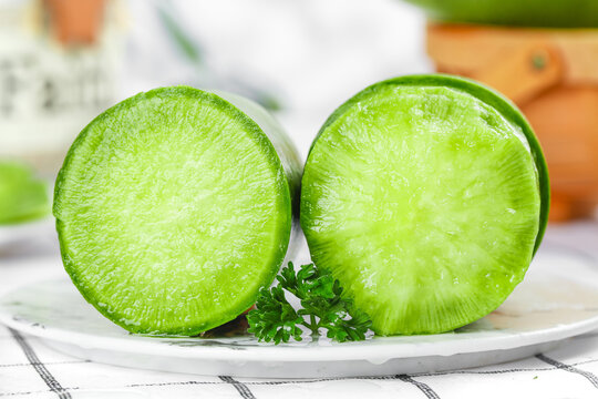 Fresh Green Radish Halves with Emerald Flesh and Parsley Garnish on White Plate