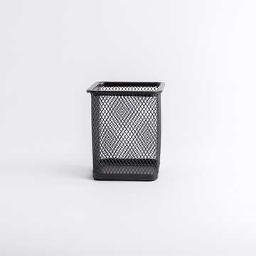 Empty black square metal mesh pen holder isolated on a white background
