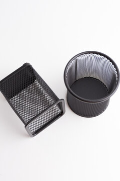 Two empty black metal mesh pen holders square and round isolated on white