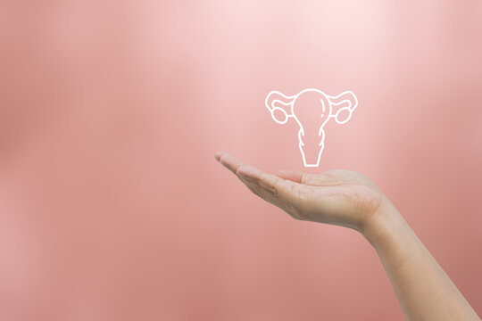 woman hand show uterus symbol on beige background represent about  health checkup and lifestyle for health and wellness concept