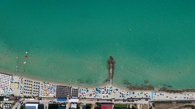 Turquoise sea meeting an organized sandy beach