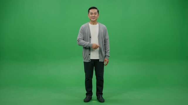A full shot of an Asian man standing and pointing to the left on a green screen background.