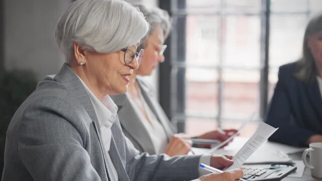 Elderly ladies in board of directors in modern international financial company. Mature women working in office, making decisions and solving problems, strategic thinking and business development