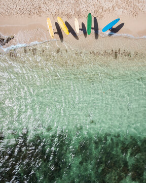 Colorful surfboards lined up on a tropical beach