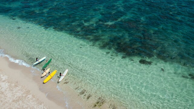 High angle view of surfers with boards at the shoreline