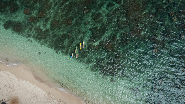Group of people paddleboarding in clear ocean water