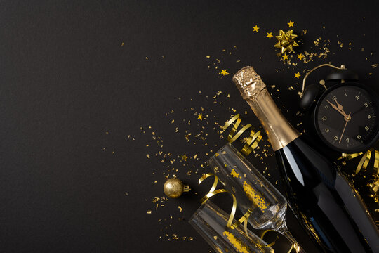 Elegant black and gold New Year 2027 celebration flatlay with champagne bottle, glasses and clock