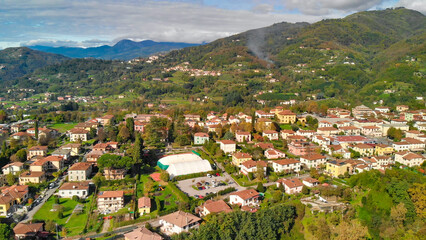 Fototapeta premium Beautiful aerial view of Barga, nestled in the Garfagnana valley, bathed in sunlight