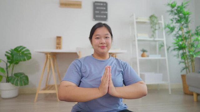 Asian plus-size woman exercising to lose weight in living room at home. 