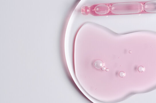 Pink cosmetic product for skin care. A serum or body gel or a moisturizer. Copy space