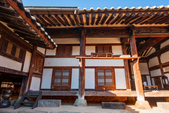 Traditional Korean hanok vernacular architecture horizontal composition featuring symmetrical windows, wooden pillars, and tiled roof eaves