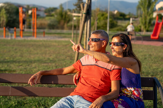 Couple watching total solar eclipse with excitement and wonder in nature