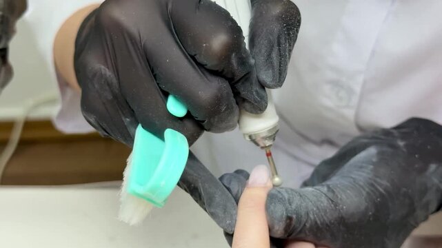  Hardware manicure: nail technician cleaning cuticle with ball bit &mdash; close‑up