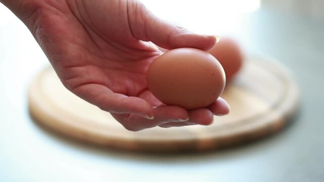 Female Hand Holding Whole Boiled Egg for Healthy Protein Breakfast