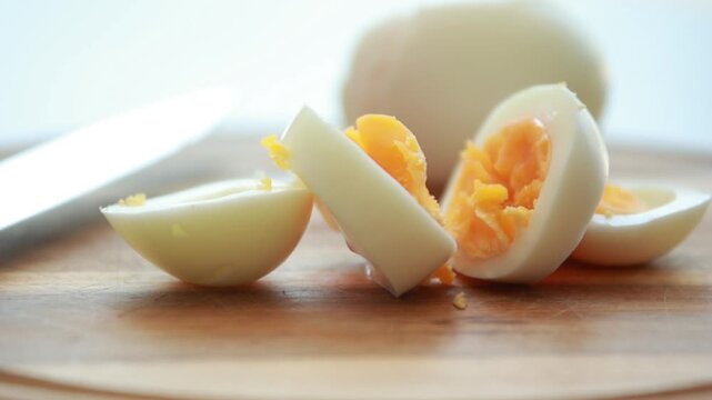 Sliced Hard Boiled Eggs arranged on Wooden Cutting Board Close Up