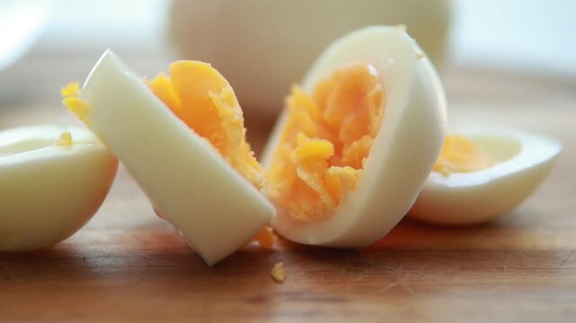 Sliced Hard Boiled Eggs arranged on Wooden Cutting Board Close Up