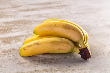 Fresh yellow bananas on textured surface © Andrei Starostin