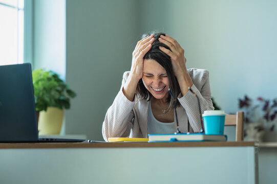 Stressed businesswoman experiences a headache at the home office