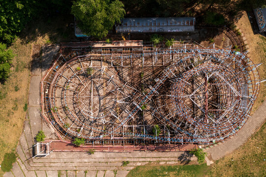 Aerial view of the abandoned roller coaster in the amusement park with rusted metal tracks and overgrown vegetation in Elektrenai, Vilnius County, Lithuania.