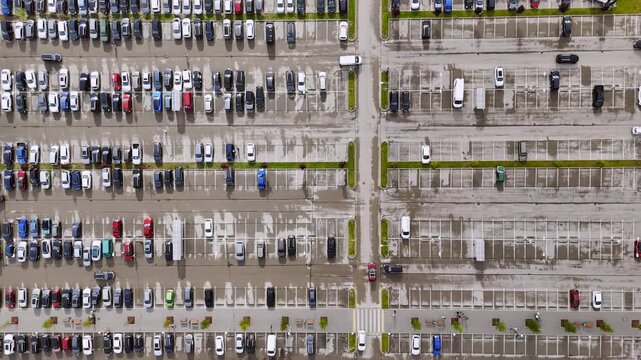 Aerial view of a large parking lot filled with many parked cars in Riga, Latvia.