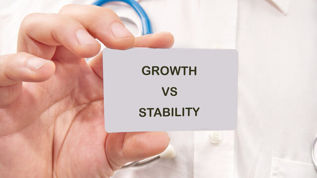 A person holds up a card that reads growth versus stability. The setting appears to be a healthcare environment. The focus is on exploring different approaches and outcomes