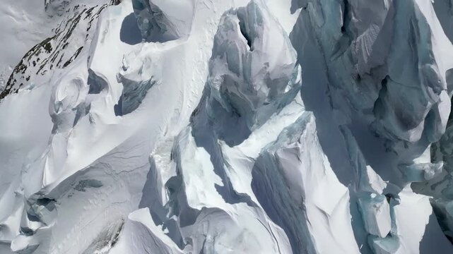 Aerial view of the rugged, snow-covered glacier terrain near Schonbielhutte SAC with deep crevasses and icy peaks in Zermatt, Wallis, Switzerland.