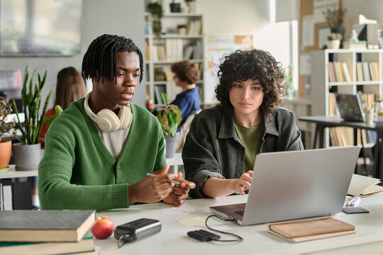 Young man and young woman learn together using a laptop indoors