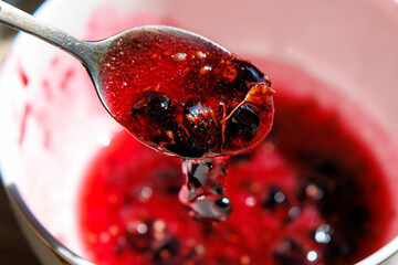 Red berry jam drips from a spoon © schankz