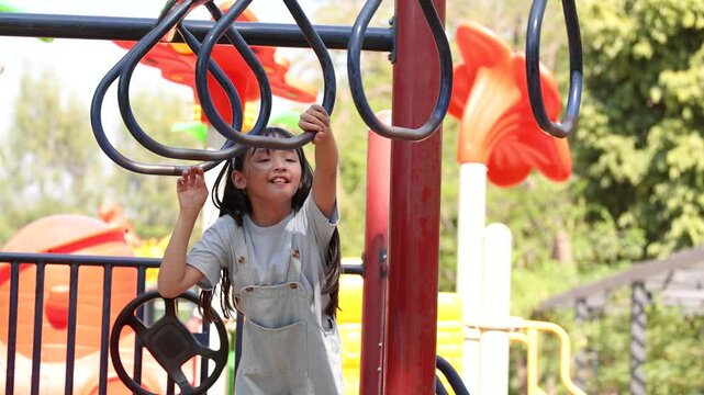 Little Asian Girl Climbing Monkey Bars at Lumpini Park Playground