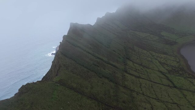 Aerial view of Caldeirao crater lake and steep cliffs Vila do Corvo, Acores, Portugal.