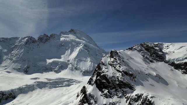Aerial view of the snow-covered peaks surrounding the Schonbielhutte SAC mountain hut under a clear blue sky in Zermatt, Wallis, Switzerland.