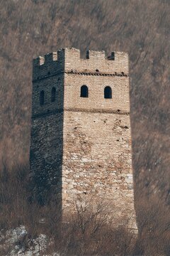 A historic stone watchtower rises amidst barren landscape, showcasing its ancient architecture and resilience, Ideal for travel blogs, history articles, or showcasing cultural heritage,