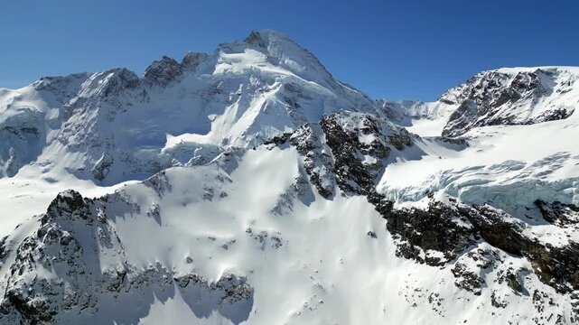 Aerial view of snow-covered mountain peaks and glaciers in the high alpine landscape near Zermatt, Wallis, Switzerland.