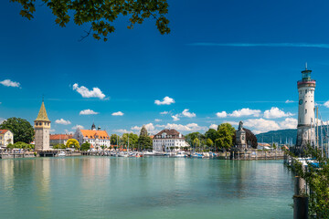 Obraz premium Historic Lindau harbor with lighthouse and lion statue on Lake Constance ideal for travel and tourism