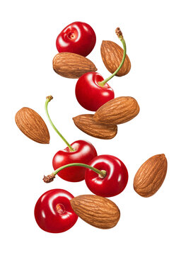 Red sweet cherry and almond nuts falling isolated on white background