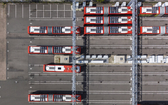 Aerial view of red electric buses parked in orderly rows at a charging station in a bus depot in Haarlem, Noord-Holland, Netherlands.