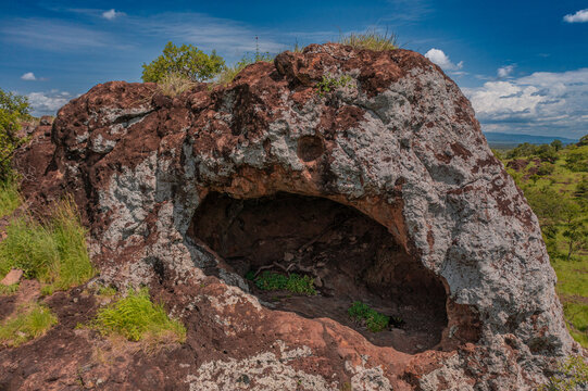View of the weathered rock formation with a natural cave opening at Pian Upe Game Reserve in the savanna landscape of Namalu, Northern Region, Uganda.
