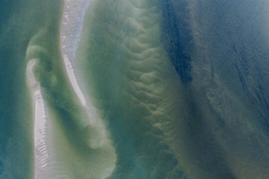 Aerial view of the sandbanks at Pontal da Barra do Mamanguape, featuring intricate patterns in the shallow turquoise water and white sand deposits in Rio Tinto, Paraiba, Brazil.