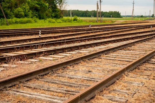 View of parallel railway tracks stretching into the distance with wooden sleepers and gravel ballast in the countryside of Pakruojis, Siauliai County, Lithuania.