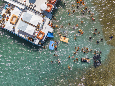 Aerial view of Piscinas naturais em Ponta do Seixas with people swimming in clear turquoise water around a floating platform and coral reefs in Joao Pessoa, State of Paraiba, Brazil.