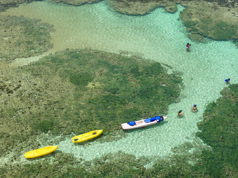 Aerial view of Piscinas naturais em Ponta do Seixas with colorful kayaks and people swimming in crystal clear turquoise natural pools in Joao Pessoa, State of Paraiba, Brazil.